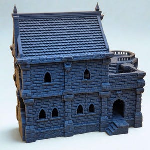 May include: A dark blue, 3D-printed miniature building featuring a two-story stone structure with a tiled roof, arched windows, and a side terrace with stairs. The exterior walls display a detailed brick pattern, and the roof has pointed finials.