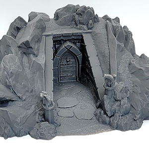 Könnte beinhalten: Ein grauer Miniatur-Fantasy-Dungeon-Eingang, der in einen felsigen Berg geschnitzt wurde. Der Eingang verfügt über eine Holztür, einen Steinbogen und einen Weg nach innen. Das felsige Äußere hat detaillierte Texturen.