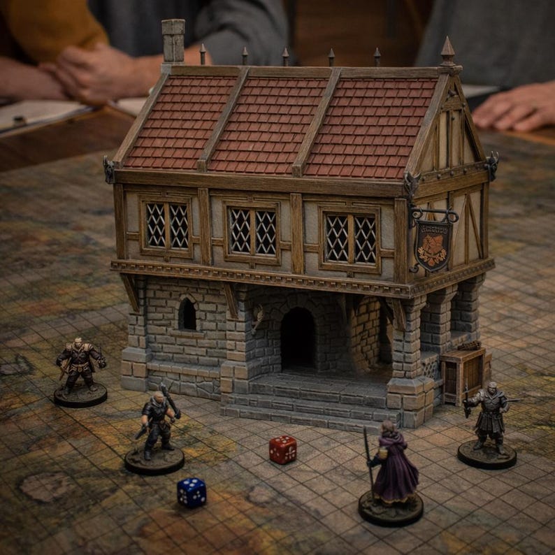 May include: A miniature two-story building with a brown shingled roof, timber-framed upper walls, and a stone-textured ground floor. A hanging sign is attached to the side. Four small character figurines and two dice are placed on the grid surface.