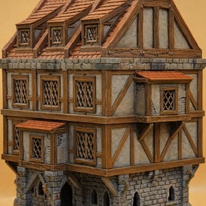 May include: A detailed model of a medieval-style building with a stone base and timber-framed upper levels. The roof is tiled in shades of red and brown. The windows have diamond-shaped lattice patterns. The text "SUPPORT-FREE PRINT" is visible at the bottom.