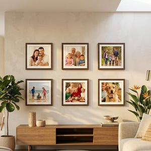 May include: A gallery wall arrangement featuring six square, dark brown wooden frames containing various family photographs, including portraits of adults, children, and a golden retriever, displayed in a two-by-three grid on a light wall.