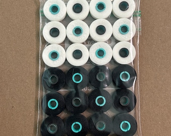 Może przedstawiać: Przezroczysty plastikowy pakiet zawierający 16 szpulek nici. Szpulki są ułożone w czterech rzędach po cztery. Dwa górne rzędy są białe, a dwa dolne czarne. Każda szpulka ma turkusowe centrum.