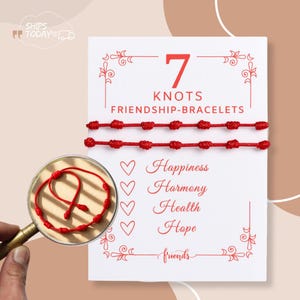 Puede incluir: Dos pulseras de amistad rojas con siete nudos se muestran en una tarjeta blanca. La tarjeta dice "7 Knots Friendship Bracelets" y enumera "Happiness, Harmony, Health, Hope" con símbolos de corazón. Una lupa muestra una pulsera.