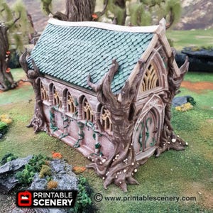 May include: A miniature fantasy building with a green tiled roof, arched windows, and a wooden facade. The structure is intricately detailed with tree-like elements and vines. The base features the text "PRINTABLE SCENERY" and a website address.