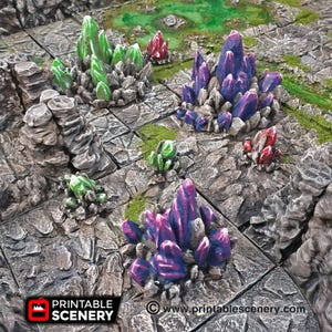 Può includere: Una collezione di gruppi di cristalli colorati, tra cui verde, viola e rosso, sono disposti su una superficie grigia testurizzata. I cristalli sono realizzati in resina e sono progettati per essere utilizzati come terreno di gioco da tavolo.