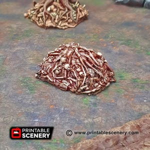 Op de afbeelding: Een stapel skeletresten, met botten en schedels die hoog op elkaar gestapeld zijn, geschilderd in een roodbruine kleur. De stapel is een 3D-geprint miniatuur, perfect voor tabletop-gaming of het schilderen van miniaturen.