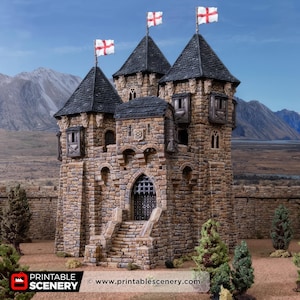 May include: A miniature stone castle with three towers, each topped with a black roof and a flag bearing a red cross. The castle has arched windows and a gated entrance. The background features a mountain range and a blue sky.