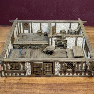 May include: A miniature wooden building with a white stucco exterior and a brown wooden roof. The interior is furnished with a fireplace, a table and chairs, and barrels. The building is designed for use in tabletop role-playing games.