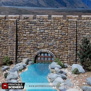 May include: A miniature stone castle wall with a water stream flowing through an arched gate. The wall is made of various shades of brown stones. The water is a bright blue color. The website address www.printablescenery.com is visible.