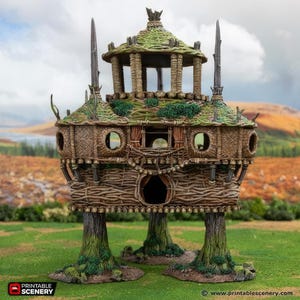 Op de afbeelding: Een gedetailleerde miniatuur fantasie boomhut met een gevlochten houten buitenkant, groen mosachtig dak en meerdere niveaus. De boomhut wordt ondersteund door drie boomstam poten en heeft ronde ramen en een decoratief balkon. De afbeelding bevat de tekst "Printable Scenery".