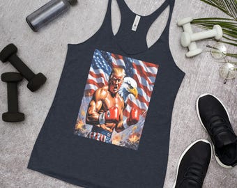 May include: Navy blue tank top featuring a vibrant graphic of a muscular boxer with the American flag and an eagle in the background. The boxer is wearing red gloves. The image is surrounded by fitness equipment and athletic shoes.