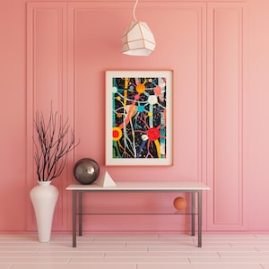 Puede incluir: Una l&aacute;mpara colgante blanca y geom&eacute;trica cuelga sobre una mesa consola con un marco de metal negro. La mesa tiene una superficie blanca y un orbe redondo gris oscuro en la parte superior. Una pintura abstracta enmarcada con formas y l&iacute;neas coloridas sobre un fondo negro cuelga en la pared detr&aacute;s de la mesa. La pared es de color rosa p&aacute;lido.