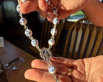 Glazen rozenkrans met blauwe bloemen, wonderbaarlijke medaille, stalen kruisbeeld