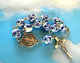 Rosario para coche con cuentas de flores azules y crucifijo de San Benito