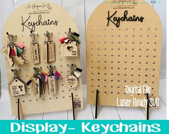 May include: Wooden keychain display with keychains featuring various designs and colorful tassels. The display includes keychains with phrases like "Mom's Taxi" and "Drive Safe." The display is designed for 14 MDF and 14 HD Maple.