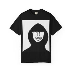 Puede incluir: Camiseta negra con un gráfico rectangular blanco que representa la cara de una figura encapuchada. La ilustración es un simple dibujo lineal de estilo minimalista. La camiseta está hecha de un material suave y tiene cuello redondo.