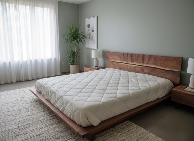K&ouml;nnte beinhalten: Ein modernes Schlafzimmer mit einem Holzrahmenbett und einem Kopfteil mit nat&uuml;rlicher Kante. Das Bett ist mit einem wei&szlig;en, gesteppten Steppbett ausgestattet. Der Raum hat eine neutrale Farbpalette, mit einem gro&szlig;en Fenster und einer Topfpflanze.