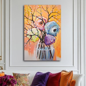 Op de afbeelding: Een schilderij van een kleurrijk boeket bloemen in een glazen vaas. De bloemen zijn roze, blauw, paars en geel. De achtergrond is licht oranje.