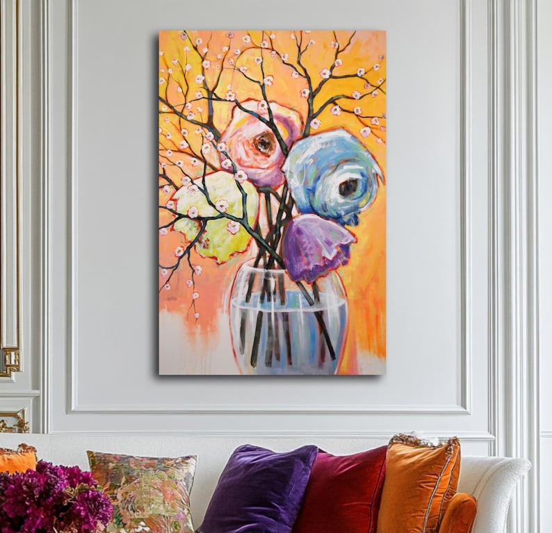 Op de afbeelding: Een schilderij van een kleurrijk boeket bloemen in een glazen vaas. De bloemen zijn roze, blauw, paars en geel. De achtergrond is licht oranje.
