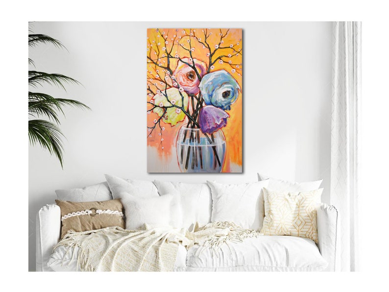 Op de afbeelding: Een schilderij van een boeket kleurrijke bloemen in een heldere glazen vaas. De bloemen zijn roze, paars, blauw en geel. De achtergrond is warm oranje.