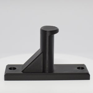 May include: A black plastic hook with a triangular base and a rounded top. The hook is designed to be mounted on a wall or other surface.