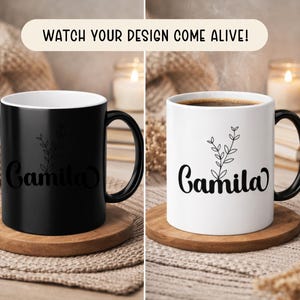 May include: Two ceramic mugs, one black and one white, each with a black handle and the name "Camila" in a script font. A floral sprig design is above the name. The black mug is on a wooden coaster. The white mug contains coffee and is also on a wooden coaster. Text above the mugs reads "WATCH YOUR DESIGN COME ALIVE!"
