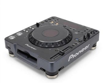 May include: A dark gray Pioneer DJ media player featuring a large central jog wheel, a slot-loading disc drive on the front, and various control buttons, sliders, and knobs on the top surface. The unit is supported by four circular feet.