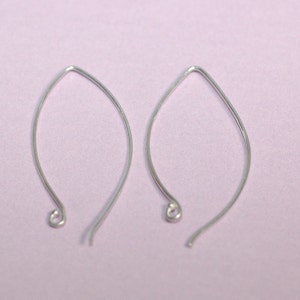 May include: Two silver teardrop-shaped earring hooks. The hooks are made of thin wire and have a small loop at the top.