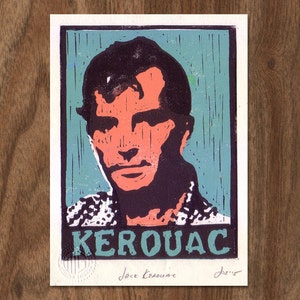 May include: A teal blue and black linocut print of Jack Kerouac. The print features a close-up portrait of Kerouac with his name in bold white letters at the bottom. The print is signed "Jack Kerouac" and "DeWitt" in the bottom right corner.