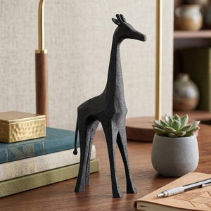 May include: A black giraffe sculpture with a textured surface. The decorative figurine has a long neck and legs, and is standing on a wooden surface. The sculpture is a decorative item for a desk or shelf.