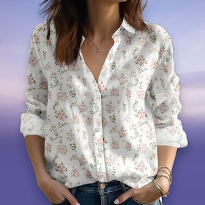 Può includere: Camicia bianca con bottoni con un delicato motivo floreale nei toni del rosa e del verde. La camicia a maniche lunghe presenta un colletto classico e una chiusura con bottoni. La stampa floreale è distribuita su tutta la camicia.