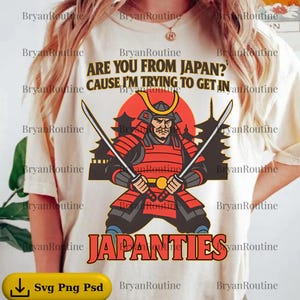 May include: Cream-colored t-shirt with a graphic of a samurai in red armor holding two swords. The text reads "ARE YOU FROM JAPAN? CAUSE I'M TRYING TO GET IN" above and "JAPANTIES" below the graphic.