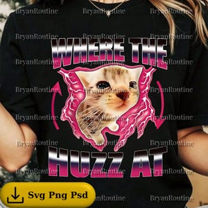 Op de afbeelding: Zwart T-shirt met een afbeelding van een katje in een roze bliksemontwerp. De tekst "WHERE THE HUZZ AT" staat in roze en wit. Het shirt heeft ook de tekst "Svg Png Psd".