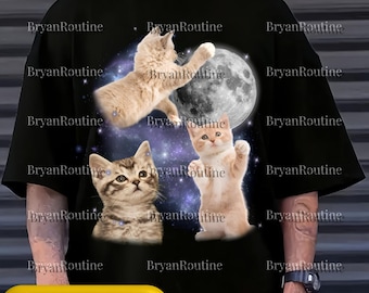 May include: Black t-shirt featuring three kittens in space with a full moon. One kitten is reaching, another is looking up, and the third is standing with paws up. The text "Svg Png Psd" is at the bottom.