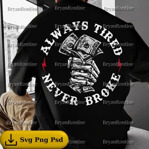 May include: Black t-shirt with a graphic design on the back. The design features a skeletal hand clutching a wad of cash, encircled by the words "ALWAYS TIRED NEVER BROKE" in white. Red lightning bolts flank the text.