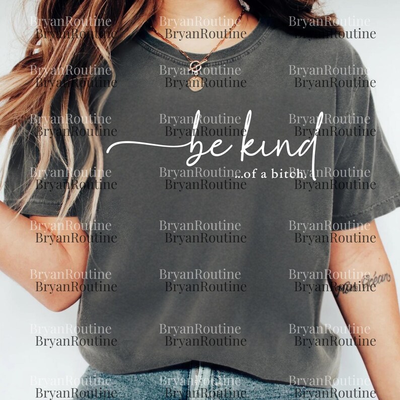 The image is a close-up of a person wearing a gray t-shirt with the text "be kind" printed on it.