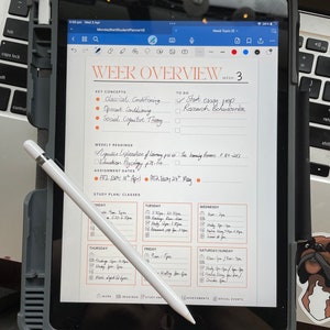 May include: A weekly planner displayed on a tablet screen with a stylus pen. The planner is organised into days of the week and features sections for study plan, classes, readings, study and assessments, and social events. The planner also includes a section for key concepts and a to-do list. The text on the screen reads "Week Overview Week 3", "Key Concepts", "Classical Conditioning", "Operant Conditioning", "Social Cognitive Theory", "Weekly Readings", "To Do", "Start essay", "Research Behaviourism", "Assignment Dates", "AT2 Essay 18th April", "AT2 Essay 24th May", "Study Plan/Classes", "Monday", "Tuesday", "Wednesday", "Thursday", "Friday", "Saturday/Sunday", "Work", "Readings", "Study and", "Assessments", "Social Events".