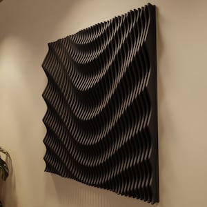 Könnte beinhalten: Ein schwarzes, dreidimensionales Wandkunstwerk mit einem wellenartigen Design. Das Kunstwerk besteht aus zahlreichen parallelen, gebogenen Linien, die eine strukturierte Oberfläche erzeugen. Das Stück ist an einer Wand montiert und zeigt eine moderne Ästhetik.
