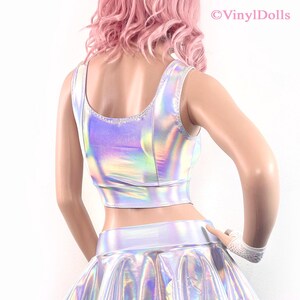 May include: A silver iridescent crop top and skirt set. The top has a scoop neck and sleeveless design. The skirt is a mini skirt with a high waist.