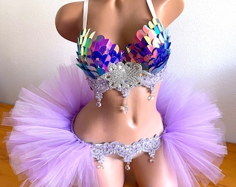 May include: A purple and blue iridescent bra with a silver and crystal embellishment, paired with a lavender tulle skirt.