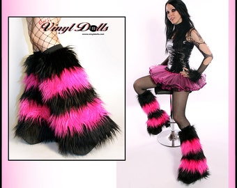 May include: Black and hot pink faux fur leg warmers with a striped pattern. The leg warmers are worn by a person with black fishnet stockings and a black and pink tutu skirt.