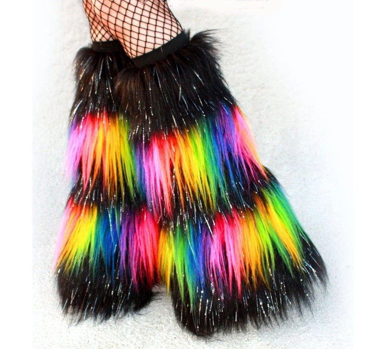 May include: Rainbow colored faux fur leg warmers with black fur and silver glitter. The leg warmers are worn over black fishnet stockings.