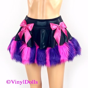 May include: A black mini skirt with a pink and purple faux fur trim. The skirt has two pink satin bows with rhinestones on the front.