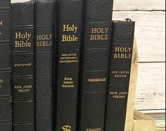 May include: A selection of black leather Holy Bibles with gold lettering. The spines feature titles like "Holy Bible," "King James Version," and "Concordance." The books are from Collins and World publishers.