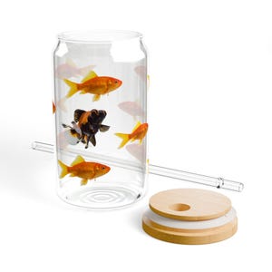 May include: A clear glass can with a bamboo lid and a straw. The can is filled with water and has several goldfish swimming inside.