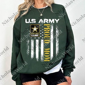 A woman wearing a green sweatshirt with a graphic design that says "U.S. Army Proud Mom" printed on it.