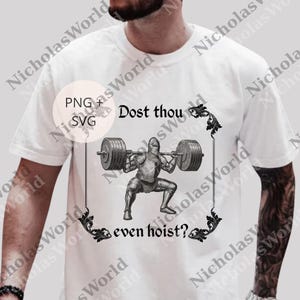 A white t-shirt with a graphic design depicting a knight lifting a heavy weight, accompanied by the text "Dost thou even hoist?"