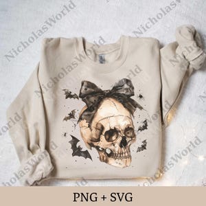 May include: A beige sweatshirt featuring a watercolor skull design with a black bow, bats, and spiders. The skull has a detailed, realistic appearance. The text "PNG + SVG" is at the bottom. A Halloween-themed apparel item.