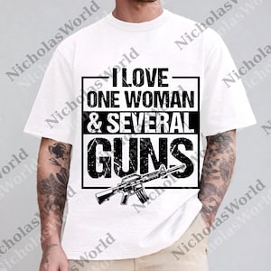 Puede incluir: Camiseta blanca con un gráfico negro. El gráfico incluye el texto "I LOVE ONE WOMAN & SEVERAL GUNS" en negrita, con una ilustración de un rifle debajo. La camiseta es de estilo casual.