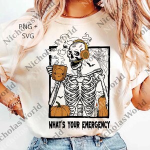 May include: Cream-coloured t-shirt with a skeleton design. The skeleton wears headphones and holds a coffee mug. The design includes a pumpkin, bats, and a spiderweb. The text on the shirt reads "WHAT'S YOUR EMERGENCY".